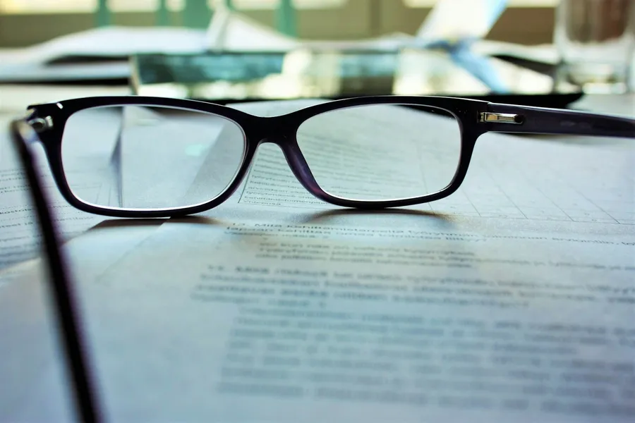 Documento legal impreso con unas gafas de lectura encima