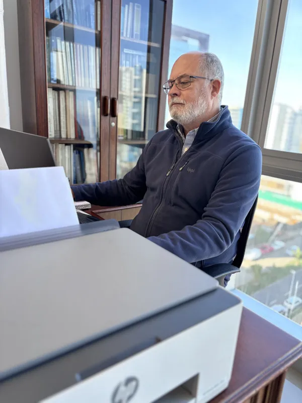 Abogado senior de CLM revisando documentación junto a la ventana de la oficina